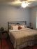 Cozy bedroom with elegant metal bedframe, plush bedding, and charming decor, perfect for relaxation.
