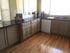 Bright, modern kitchen with sleek granite countertops, warm wood flooring, and ample cabinetry.