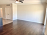 Inviting living room with elegant hardwood floors, ample natural light, and a stylish ceiling fan.