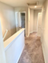 Bright and welcoming hallway with plush carpeting and a modern design, featuring convenient storage closets and sleek white finishes.