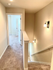 Bright and welcoming stairway with carpeted steps leading to a sunlit hallway and modern rooms.
