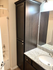 Modern bathroom with sleek dark cabinetry, granite countertop, and a convenient shower tub combination.