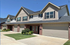 Charming townhouse with modern architecture, featuring two stories, brick and siding exterior, and spacious double garages.