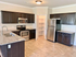 Modern kitchen with dark wood cabinets, granite countertops, stainless steel appliances, and a spacious pantry.