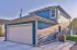 Spacious open-concept living area with elegant hardwood floors, modern ceiling fan, and a sleek kitchen with bar seating.