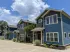 Spacious open-concept living area with elegant hardwood floors, modern ceiling fan, and a sleek kitchen with bar seating.