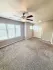 Spacious open-concept living area with elegant hardwood floors, modern ceiling fan, and a sleek kitchen with bar seating.