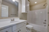 Modern bathroom with sleek white vanity, spacious countertop, and elegant fittings, offering a luxurious bathing experience.