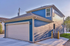 Charming blue two-story home exterior with a spacious garage and modern design.