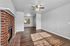 Bright living room with elegant hardwood floors, a charming brick fireplace, and a modern ceiling fan, perfect for cozy gatherings.