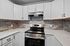 Modern kitchen with sleek stainless steel appliances, elegant white cabinetry, and stylish gray subway tile backsplash.