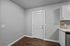 Inviting entryway with modern wood flooring, white door, and sleek kitchen countertop, perfect for a stylish apartment.