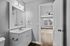Bright and modern bathroom with sleek vanity mirror and view into sunlit bedroom, showcasing stylish design and natural light.