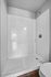 Elegant bathroom with sleek white subway tiles and a modern shower design.