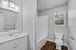 Elegant bathroom featuring a sleek vanity, modern fixtures, and a scenic window view, highlighting a fresh, minimalist design.