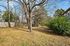 Beautiful backyard with mature trees and a wooden fence, perfect for relaxing in a serene natural setting.