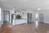 Modern open-concept apartment with sleek kitchen, stainless steel appliances, and elegant pendant lighting, featuring stylish wood flooring and ample natural light.