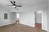 Bright and modern room featuring herringbone wood flooring, sleek ceiling fan, and a spacious walk-in closet.