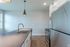 Modern kitchen with sleek countertops, stainless steel appliances, and elegant pendant lighting.