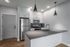 Modern kitchen with sleek stainless steel appliances, elegant pendant lighting, and a contemporary breakfast bar with granite countertops.