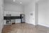 Modern kitchen with sleek stainless steel appliances, elegant herringbone wood flooring, and ample cabinetry.