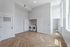 Bright, spacious room with elegant herringbone wood floors and an in-unit laundry area featuring modern washer and dryer.