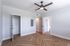 Bright, spacious room with elegant herringbone wood flooring, modern light fixture, and two open doors creating a welcoming and sophisticated ambiance.