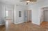 Bright and modern apartment interior showcasing elegant wooden flooring, sleek ceiling fan, and ample natural light through large windows.
