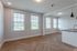 Bright and inviting living space with large windows, modern lighting, and elegant herringbone wooden flooring.