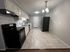 Modern kitchen with sleek stainless steel appliances, elegant white cabinetry, and stylish tile flooring.
