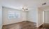 Charming living room with elegant hardwood floors, ample natural light, and a modern ceiling fan.