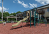 Charming apartment complex with a vibrant playground featuring slides and climbing structures, ideal for family living.