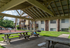 Charming outdoor area with covered picnic tables, perfect for gatherings in a tranquil apartment community setting.