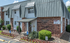 Charming brick exterior of Ruby Creek apartments, showcasing a welcoming entrance with manicured landscaping and accessible features.