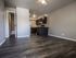 Modern apartment interior featuring elegant wood flooring, an updated kitchen with dark cabinetry, and a cozy open-plan space.