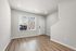 Bright and airy living space with modern hardwood floors and large window, perfect for creating a cozy home environment.