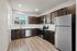 Modern kitchen with sleek stainless steel appliances, elegant dark wood cabinets, and bright natural lighting.