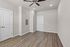 Modern apartment room with sleek hardwood floors, elegant beige walls, and a stylish ceiling fan.