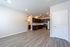 Modern open-concept kitchen and living area featuring sleek wooden cabinetry, stainless steel appliances, and elegant wood flooring.