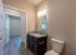 Elegant bathroom with granite countertop, modern fixtures, and view into a bright, spacious room.