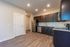 Modern kitchen featuring elegant dark wood cabinets, sleek stainless steel appliances, and stylish granite countertops with wood flooring.