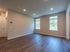 Bright, spacious empty room with large windows and elegant wood flooring, perfect for personalization.