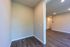 Inviting apartment hallway featuring elegant wood flooring, neutral walls, and modern recessed lighting.
