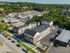 Charming aerial view of modern apartment complex surrounded by lush greenery and convenient urban amenities.