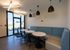 Contemporary lounge space featuring stylish pendant lighting, cozy blue and beige seating, and modern circular tables, ideal for social gatherings.