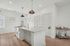 Chic modern kitchen with sleek white cabinets, elegant pendant lighting, and a spacious island perfect for entertaining.