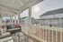 Charming covered balcony with cozy seating and scenic views of modern townhomes, perfect for relaxation.