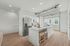 Modern kitchen with sleek stainless-steel appliances, a spacious quartz island, and elegant wood flooring, offering a bright and inviting ambiance.
