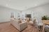 Bright and inviting living room with modern decor, featuring comfortable seating, large TV, and elegant hardwood flooring.