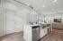 Modern open-concept kitchen with stainless steel appliances, sleek island seating, and bright living area.
